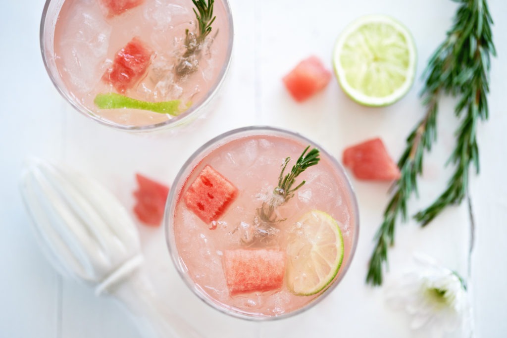Fruity watermelon cocktail/mocktail drink decorated with cubes of fresh watermelon and rosemary